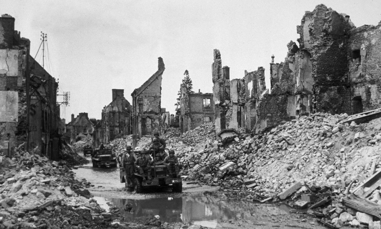13th June 1944: Americans pass through devastated Valognes, on their way towards Cherbourg. (Photo by Fred Ramage/Keystone/Hulton Archive/Getty Images)