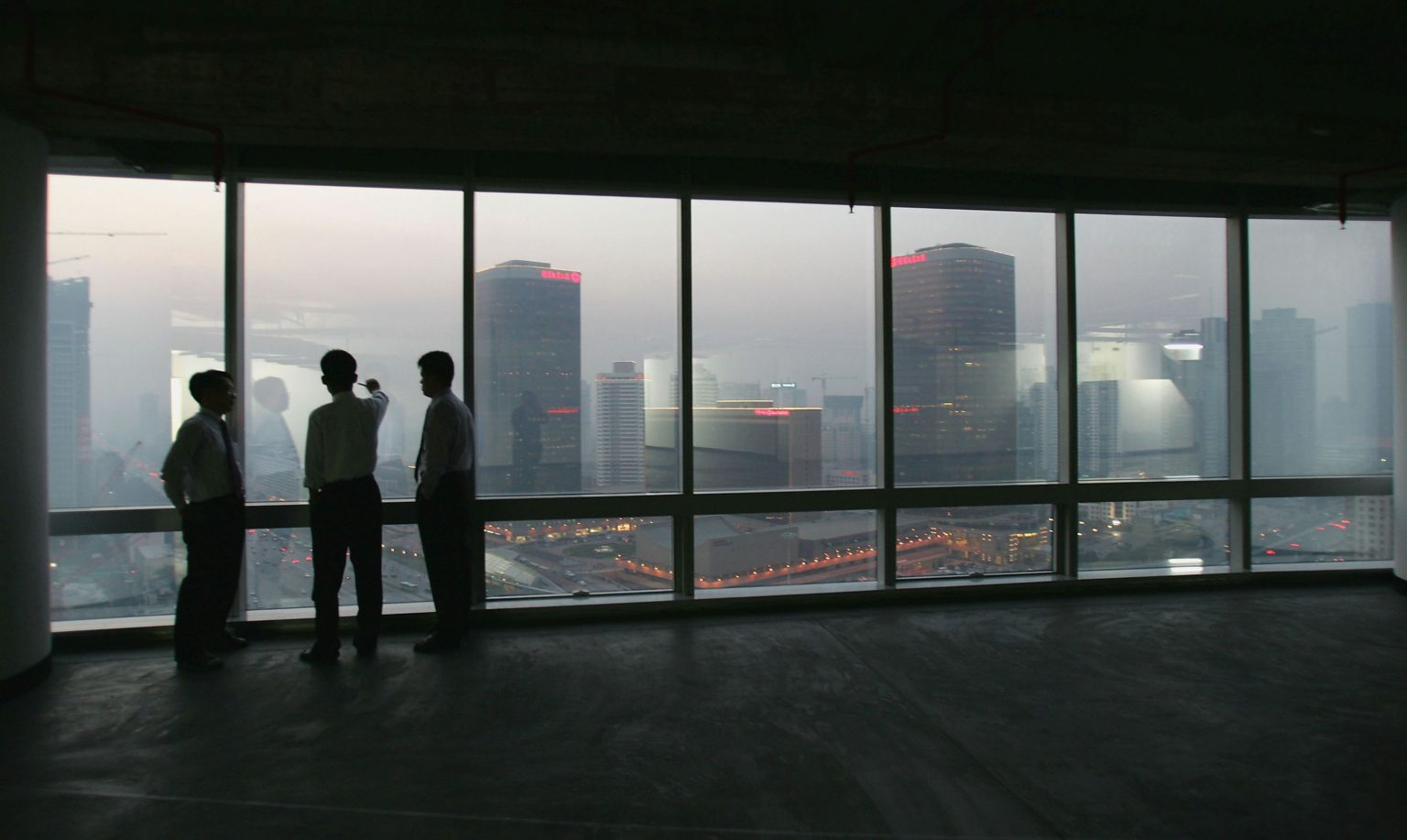 Businessmen survey Beijing's booming central business district from a new office building on 18 November 2004.