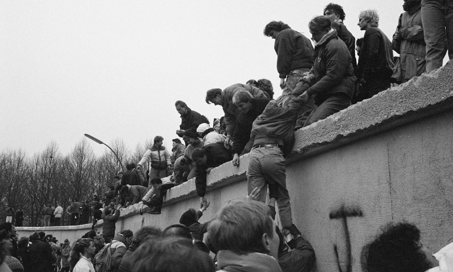 East Berliners climb onto the Berlin Wall to celebrate the effective end of the city's partition, 31 December 1989.