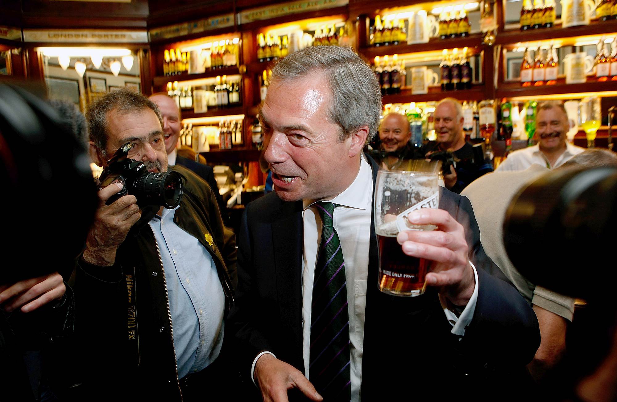 Nigel Farage, leader of UKIP, enjoys a pint after his party's triumph in the European Parliament elections, on 26 May 2014.