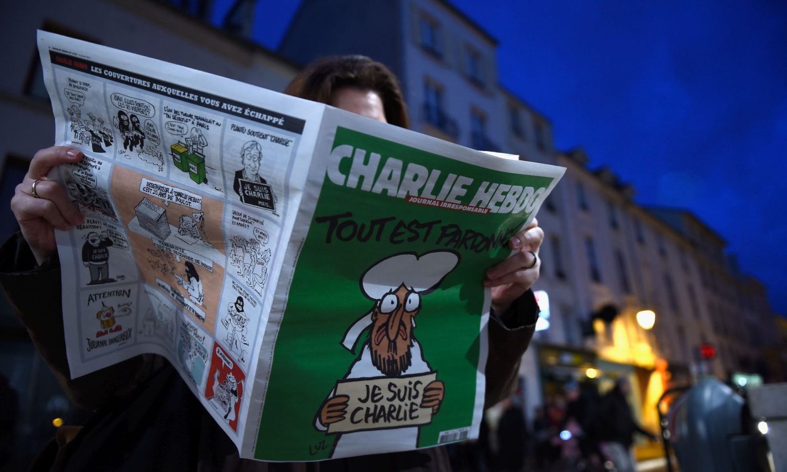 A woman reads Charlie Hebdo in Saint Germain en Laye, on 14 January 2015.