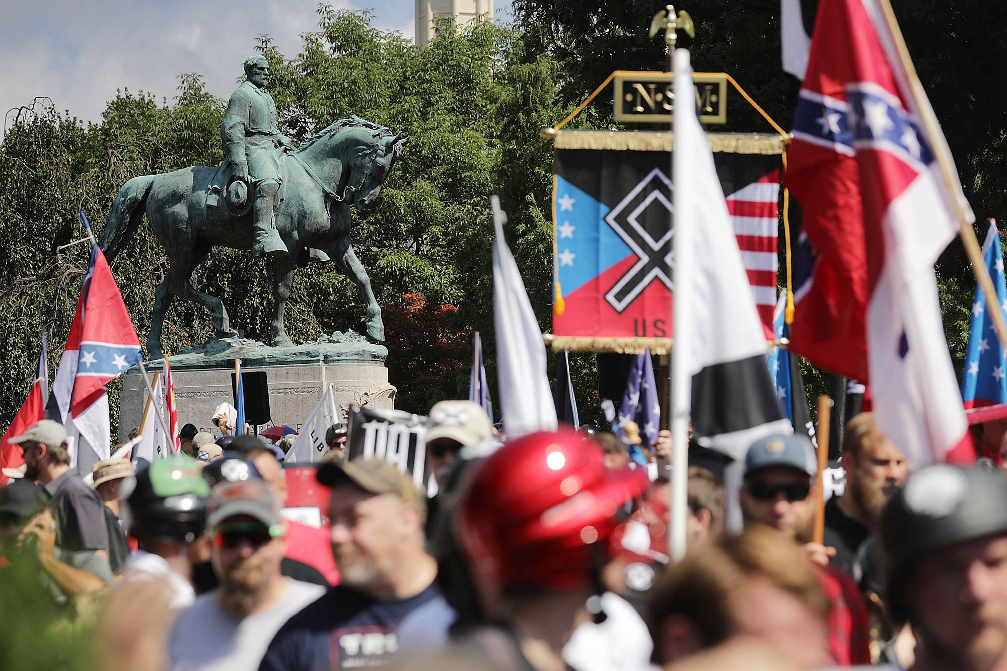 The Unite the Right rally passing the statue of Confederate General Robert E Lee, in Charlottesville, Virginia, 12 August 2017.