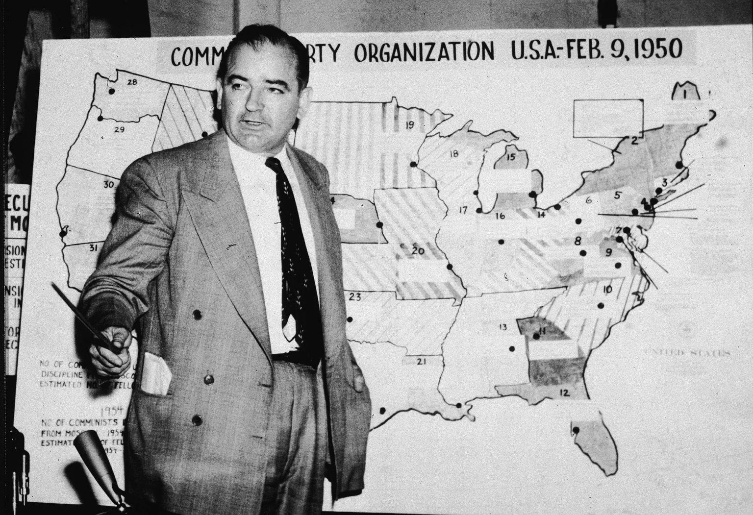 Senator Joseph McCarthy stands before a map which charts Communist activity in the United States, 9 June 1954.
