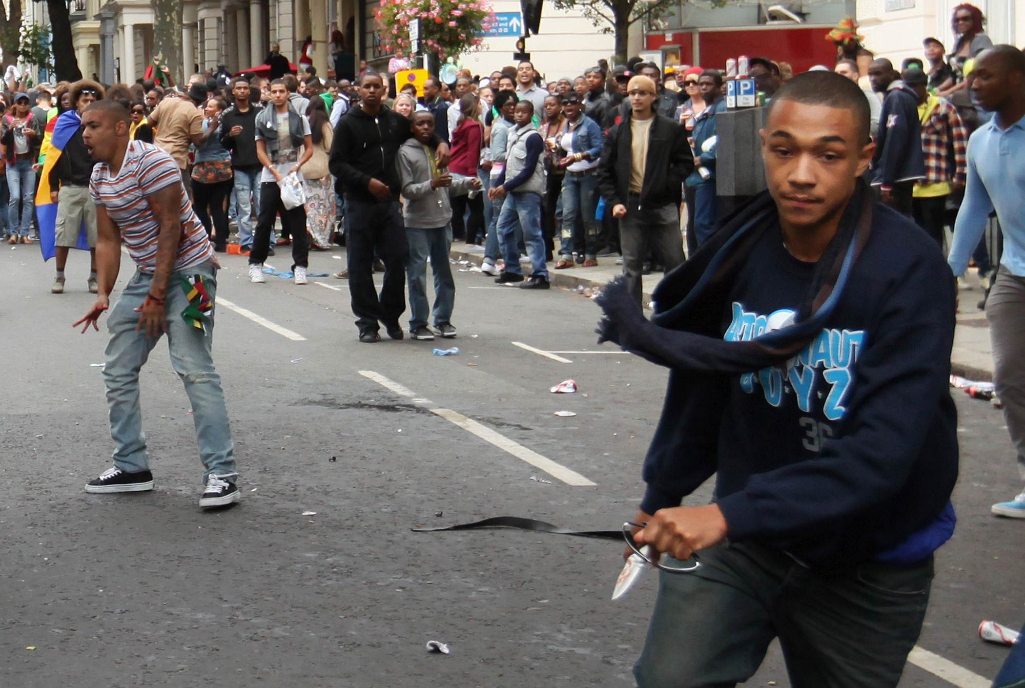 A man carrying a knife runs down the road at the Notting Hill Carnival, 29 August 2011