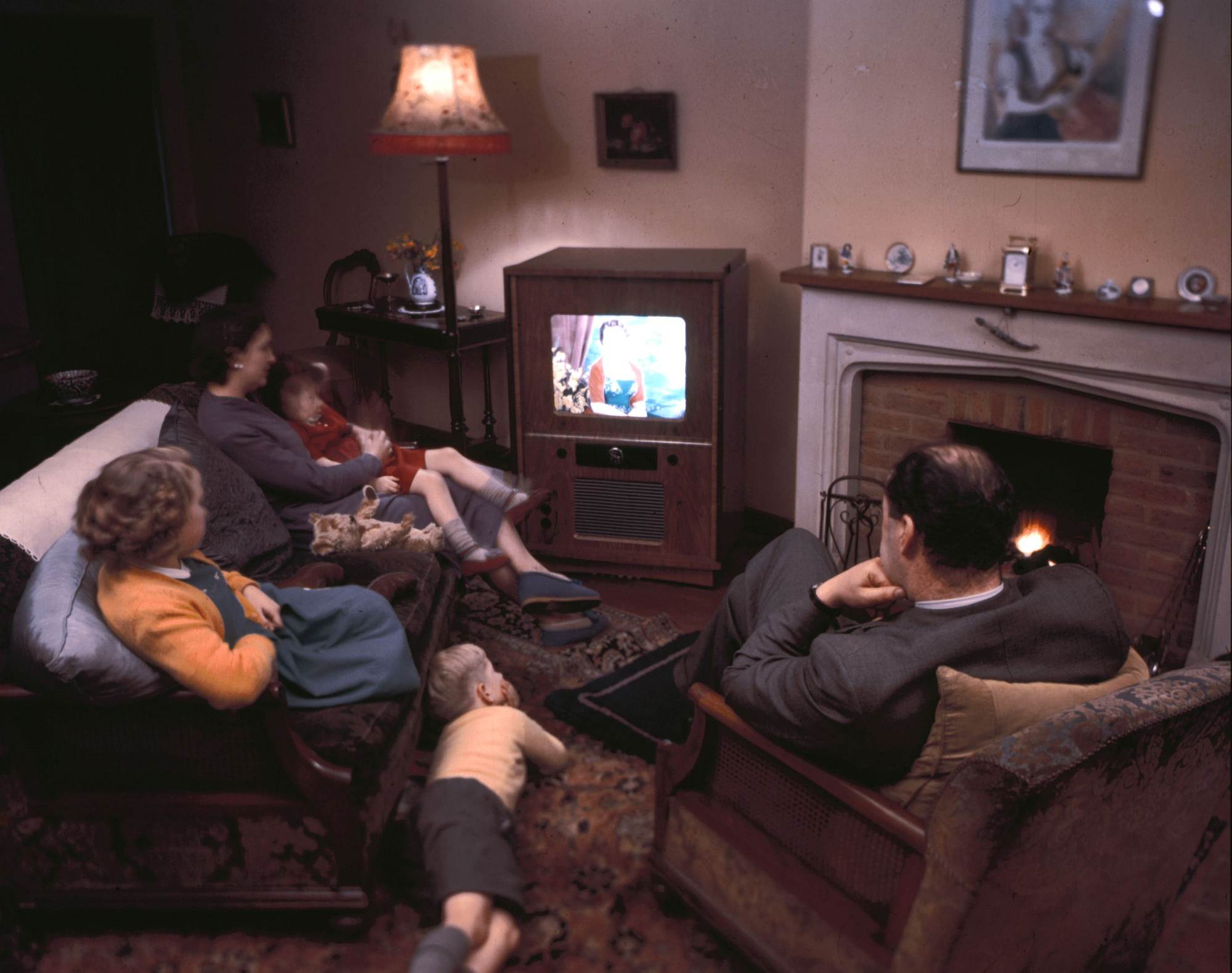 A family of five relax in front of their colour television, circa 1954