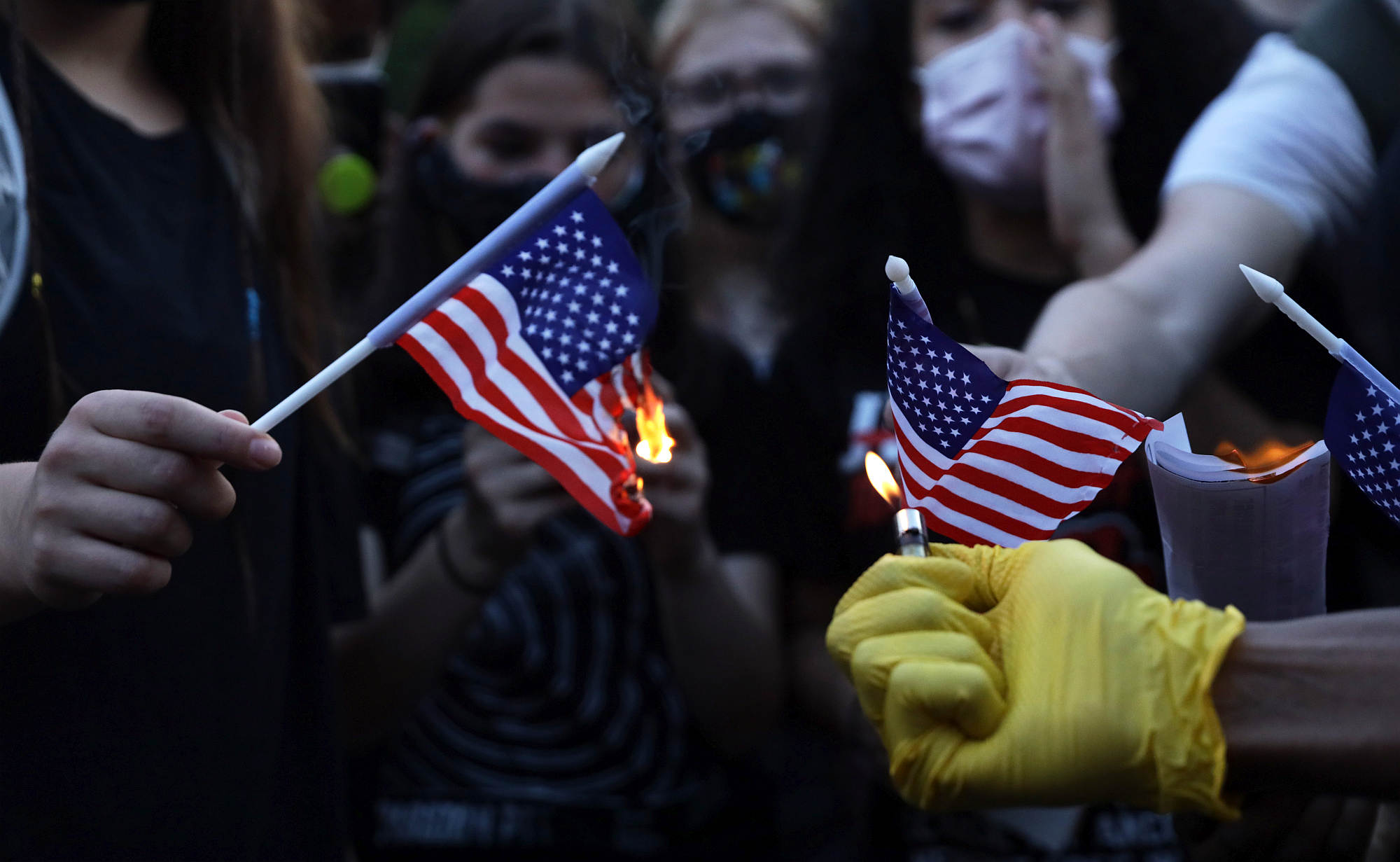 Anti-Trump activists burn US flags at Black Lives Matter Plaza near the White House 4 July 2020.