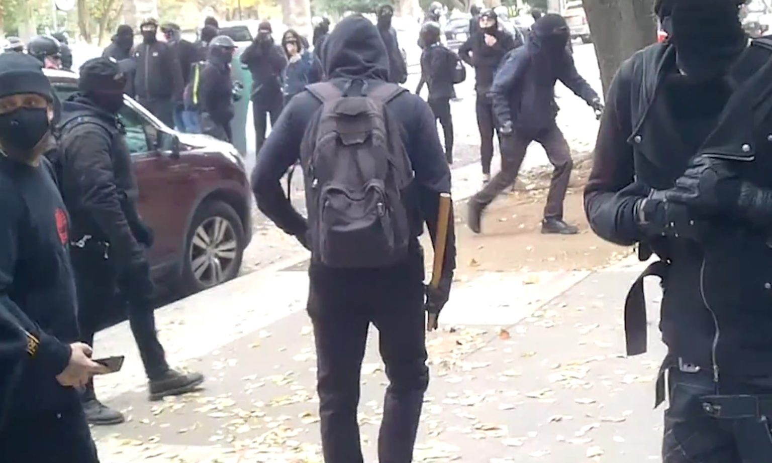 ‘They damn near killed them’, shouts an observer as a Black Bloc rioter with a club walks away from the scene where a young couple were beaten. Sacramento, California, 5 December, 2020.