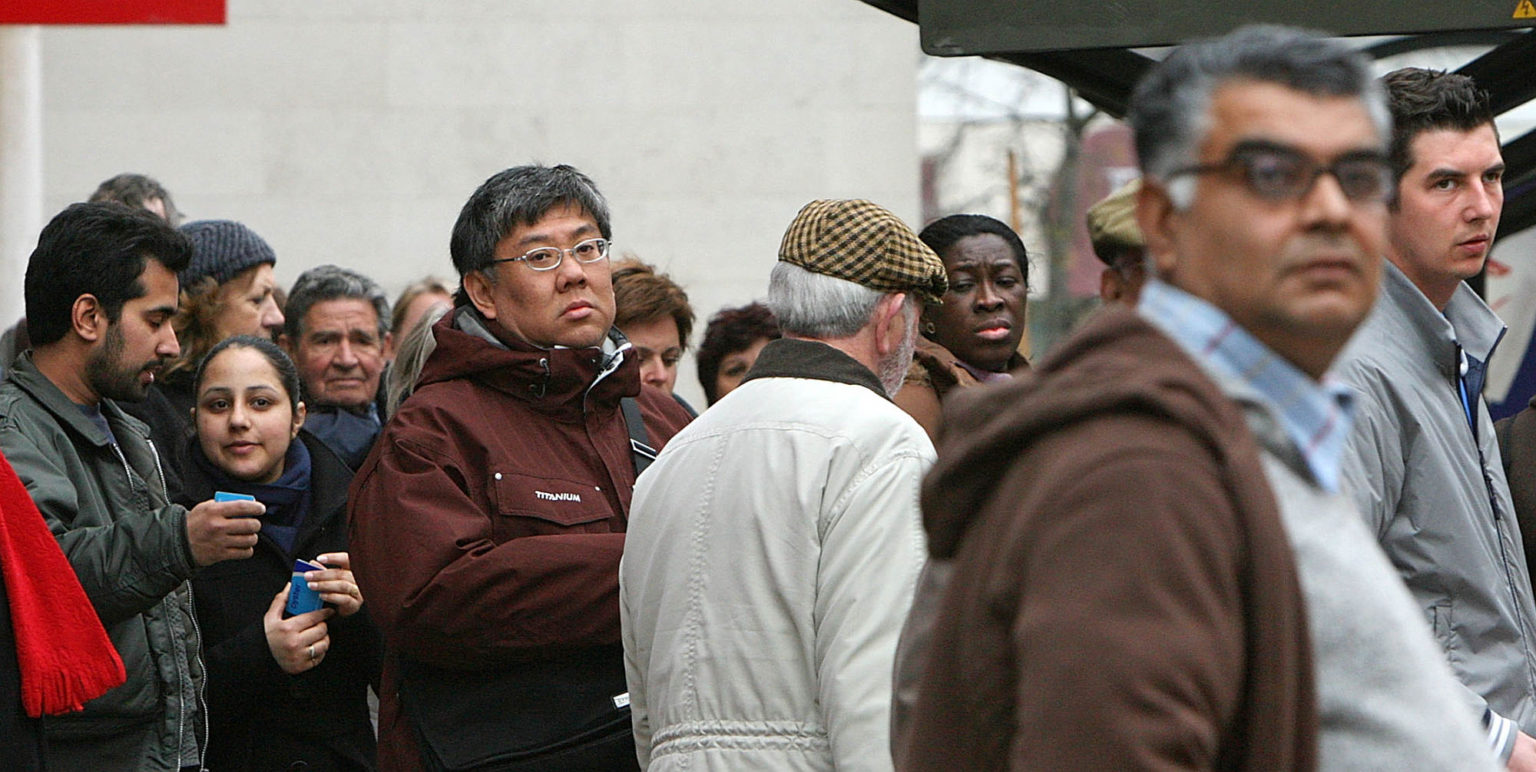 People waiting at a bus-stop in Kingston Upon Thames town centre, 19 April 2008.