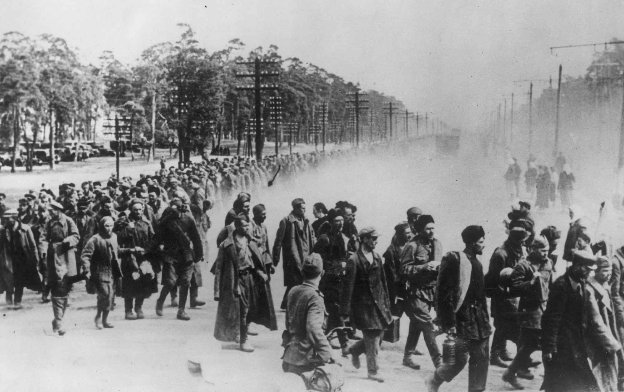 Soviet prisoners are marched to an internment camp by their Nazi guards, circa 1941. (Credit: Getty Images)