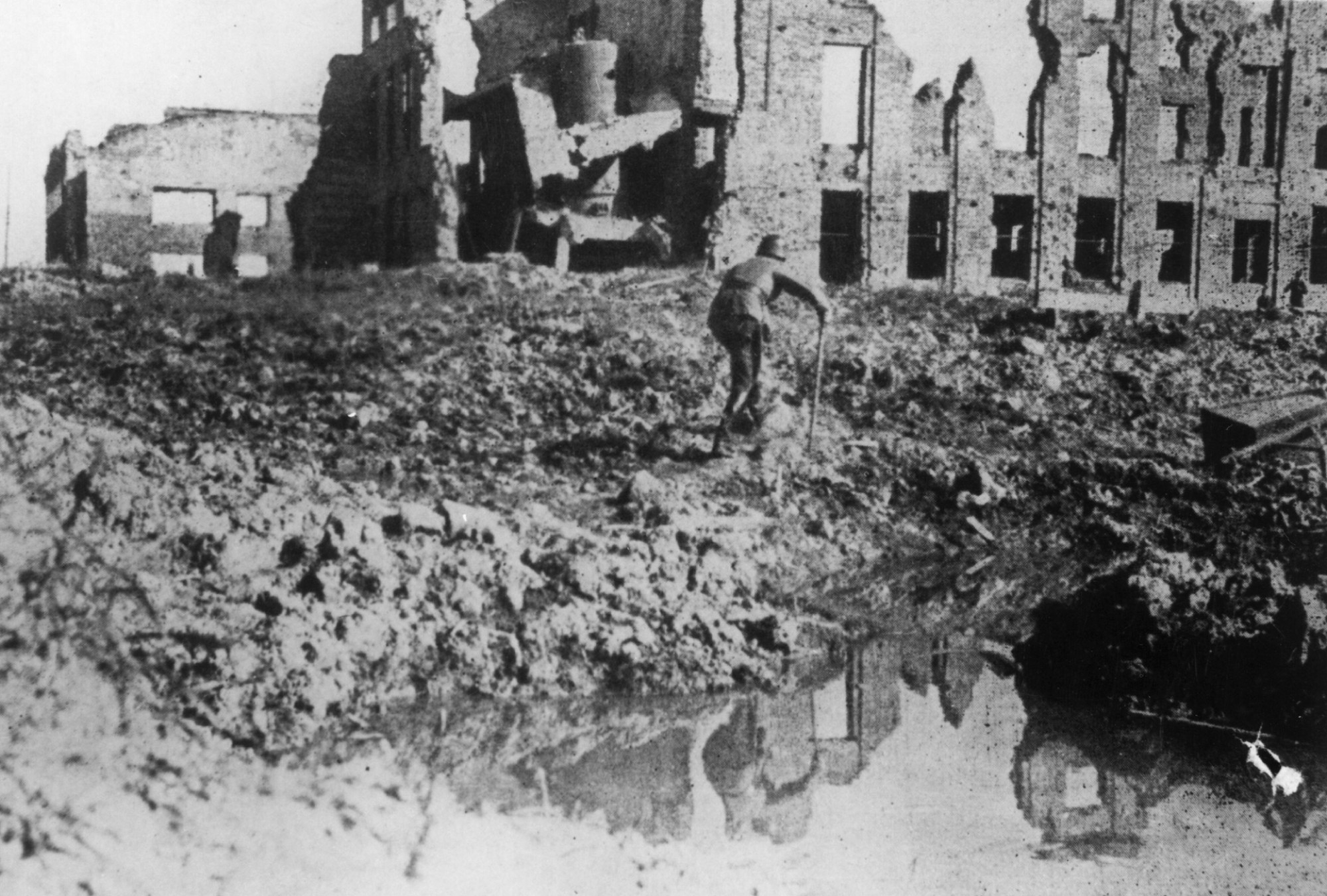 A German soldier hobbles round a waterlogged crater in Stalingrad, circa 1943. (Credit: Getty Images)