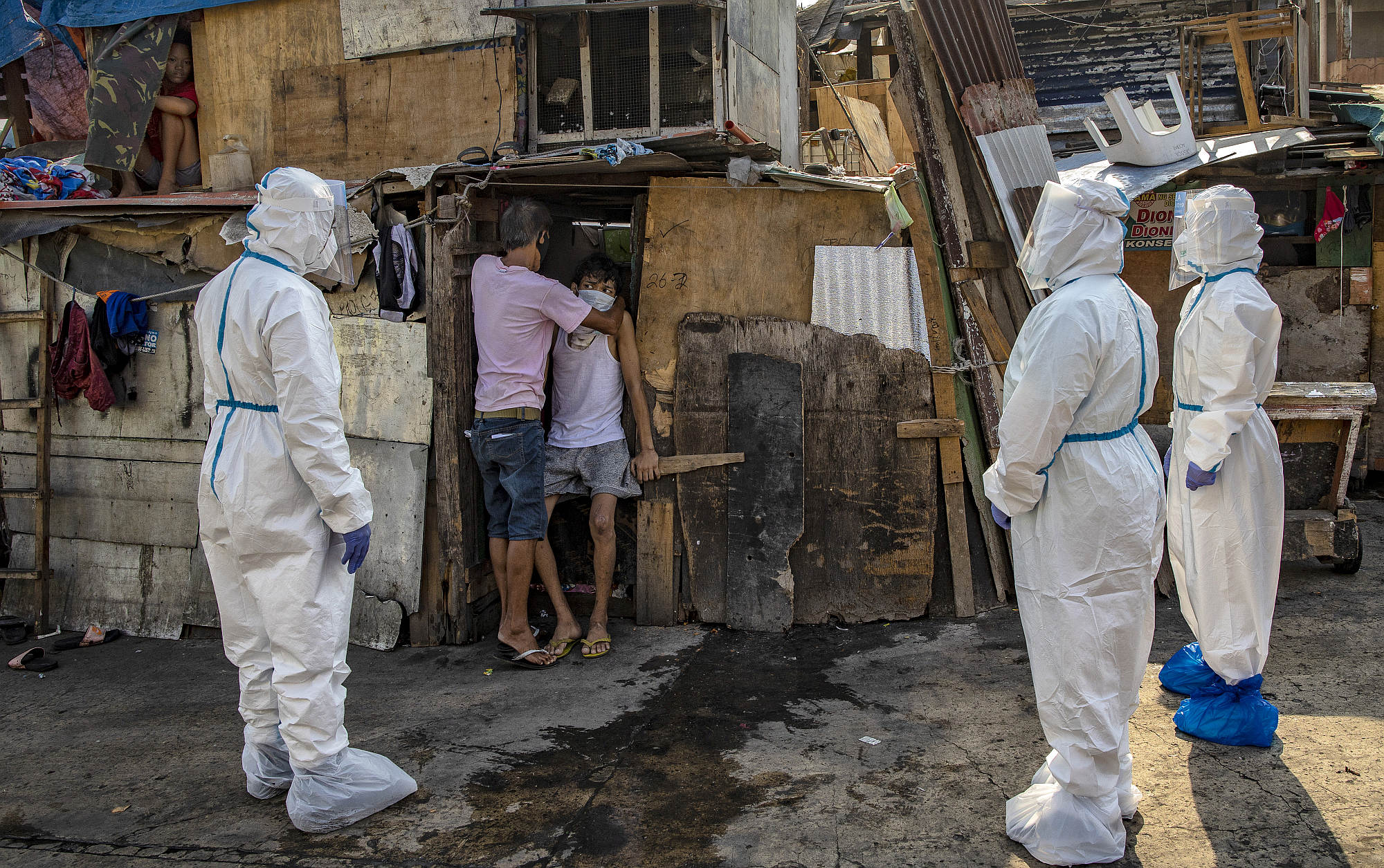 Police officers fetch a resident suspected of having Covid from his home in Manila, on 15 April 2020.