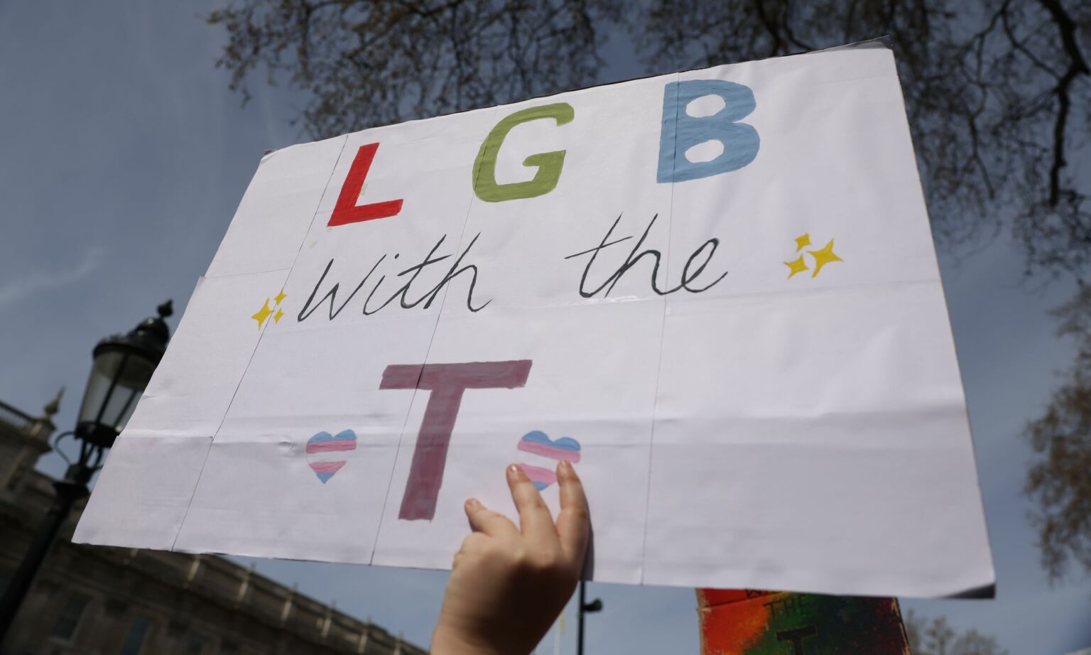 A demonstrator holds a placard during the No Ban Without Trans protest opposite Downing Street, London, on 10 April 2022.