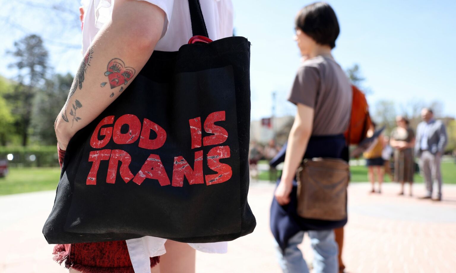 A transgender-rights activist holds a bad during a demonstration on the University of Montana campus on 3 May 2023.