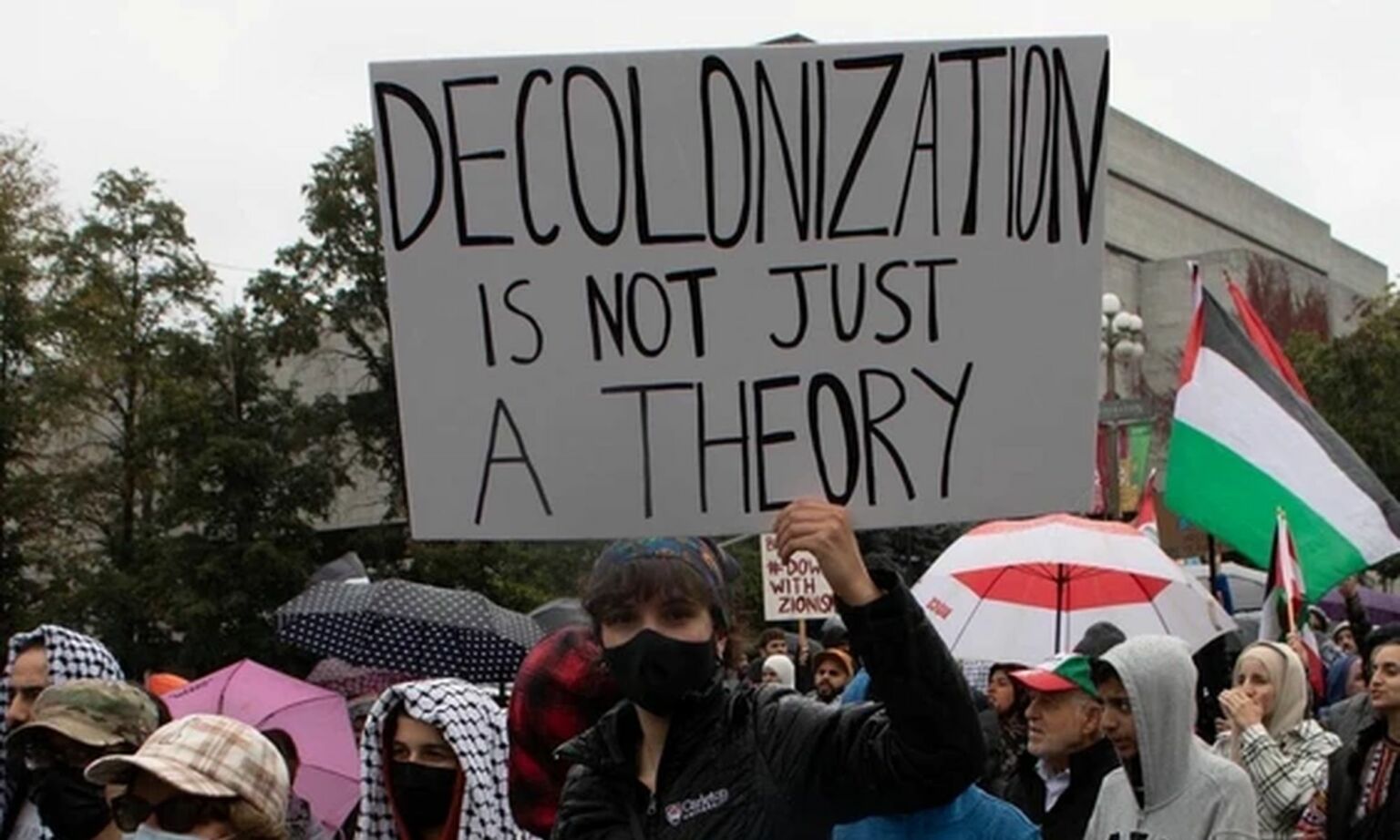 A protester holds up a sign praising decolonisation at a Canadian 'pro-Palestine' rally following Hamas' terrorist attacks on Israel, October 2023.