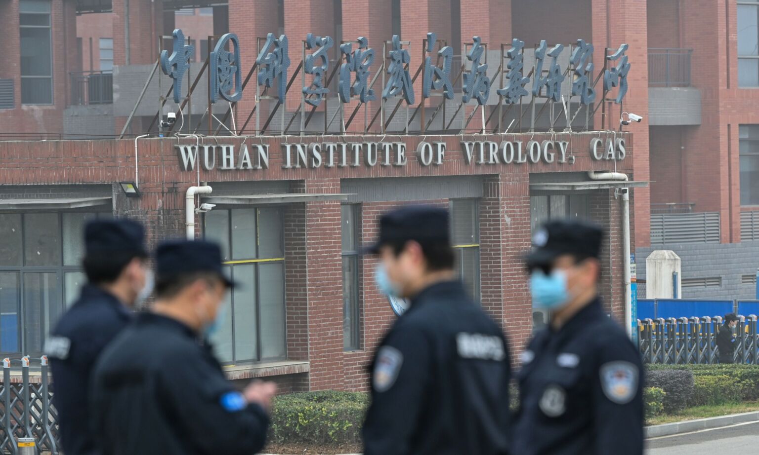 Security personnel stand guard outside the Wuhan Institute of Virology in Wuhan, 3 February 2021