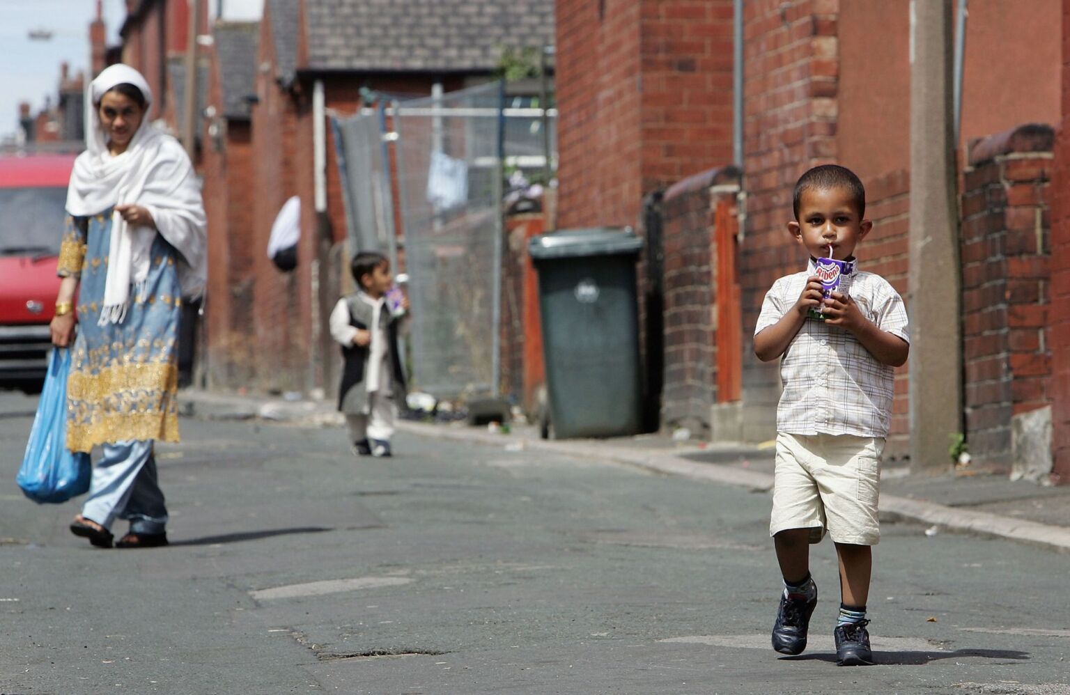 Young children play in the streets near the home of suicide bomber Shehzad Tanweer in Beeston, Leeds, 13 July 2005.
