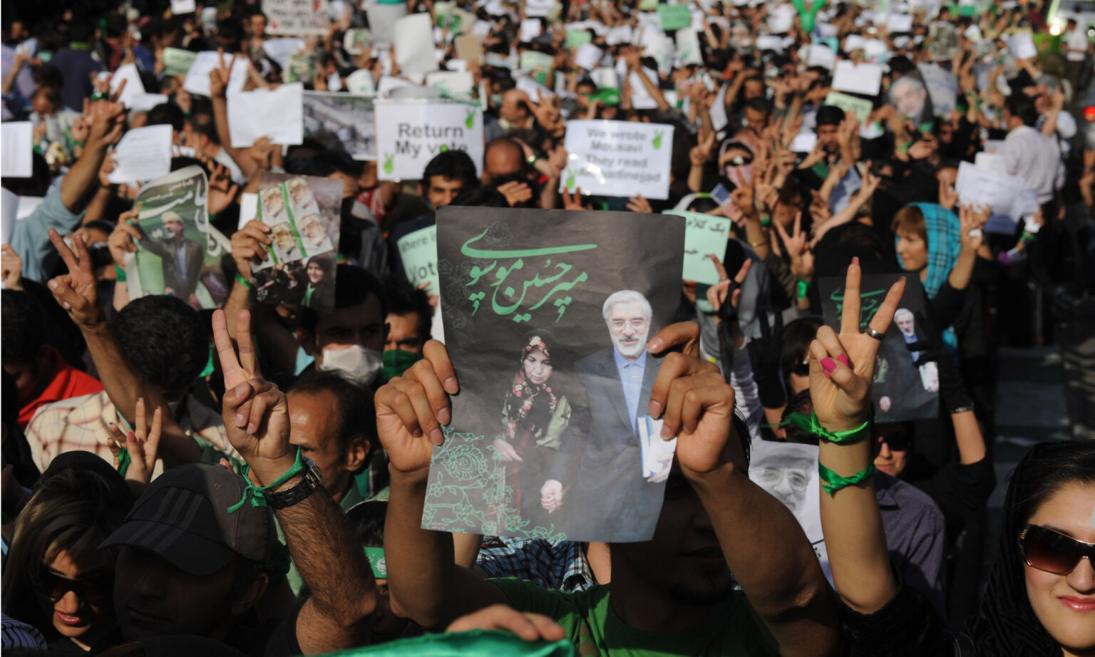 Demonstrators carry banners and pictures of Mir Hossein Mousavi, the defeated reformist candidate, during a march in Tehran, 17 June 2009. 