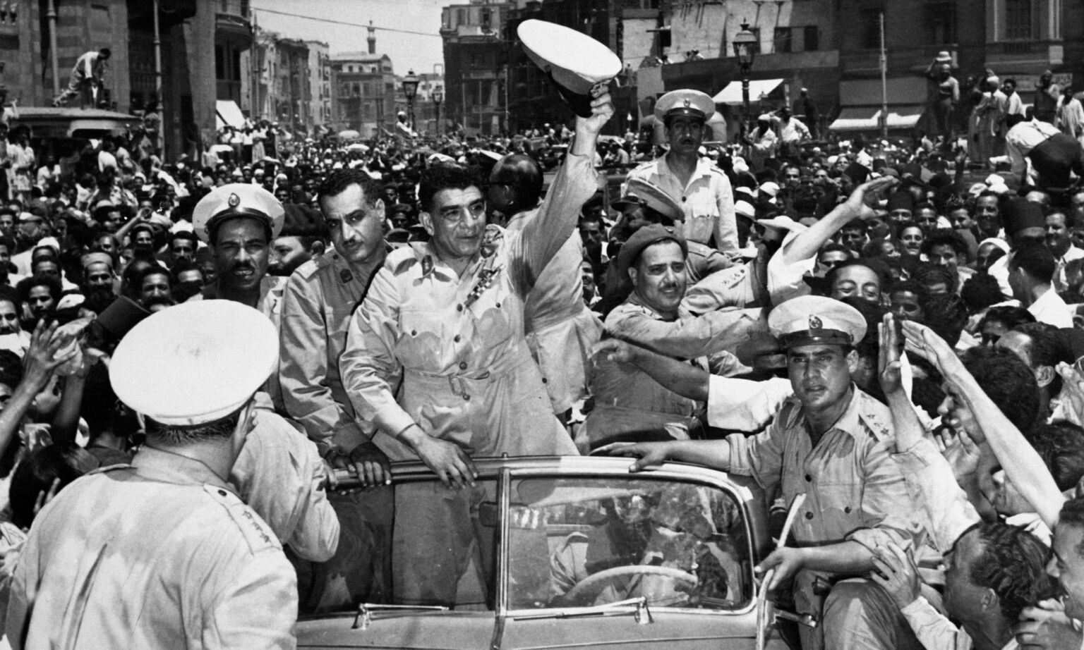 First president of Egyptian Republic general Mohammed Neguib, salutes the cheering crowd in Cairo, along with vice president of council Gamal Abdel Nasser (2nd left in car) after the proclamation of Egyptian Republic, 21 June1953.